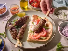 Pyszny gemuse kebab na talerzu z warzywami, sosem i pieczywem.