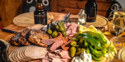 Idealne mięso na imprezę: grillowane kotlety, wędliny, ser, ogórki i papryka.