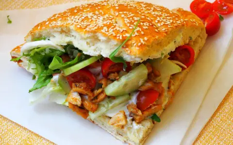 Pyszny kebab w bułce z kurczakiem, świeżymi warzywami i sosem. Idealny na szybki posiłek.