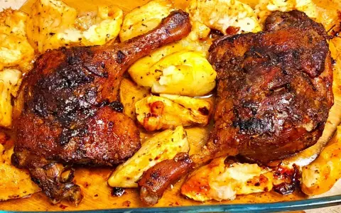 Chrupiące udko z kaczki pieczone z ziemniakami, skąpane w aromatycznym sosie.