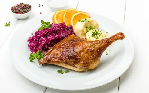 Pieczona kaczka z purée ziemniaczanym, czerwoną kapustą i pomarańczą. Idealna marynata do kaczki sprawia, że mięso jest soczyste i aromatyczne.