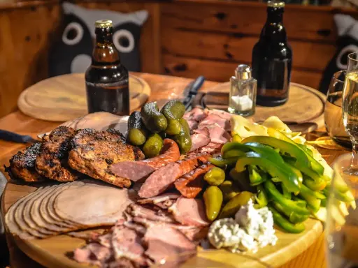 Idealne mięso na imprezę: grillowane kotlety, wędliny, ser, ogórki i papryka.