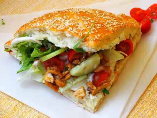 Pyszny kebab w bułce z kurczakiem, świeżymi warzywami i sosem. Idealny na szybki posiłek.