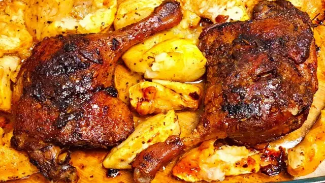 Chrupiące udko z kaczki pieczone z ziemniakami, skąpane w aromatycznym sosie.