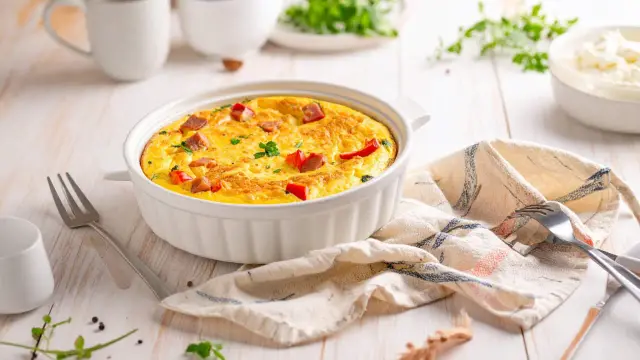 Pyszny omlet z airfryer, z kawałkami kiełbasy i papryki, udekorowany natką pietruszki, gotowy do podania.