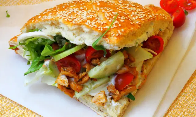 Pyszny kebab w bułce z kurczakiem, świeżymi warzywami i sosem. Idealny na szybki posiłek.