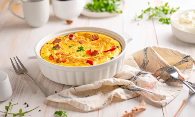 Pyszny omlet z airfryer, z kawałkami kiełbasy i papryki, udekorowany natką pietruszki, gotowy do podania.